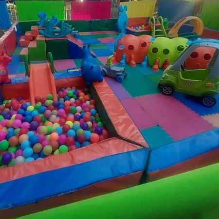 Espacio de juego con corral, pelotas y bloques Lego.